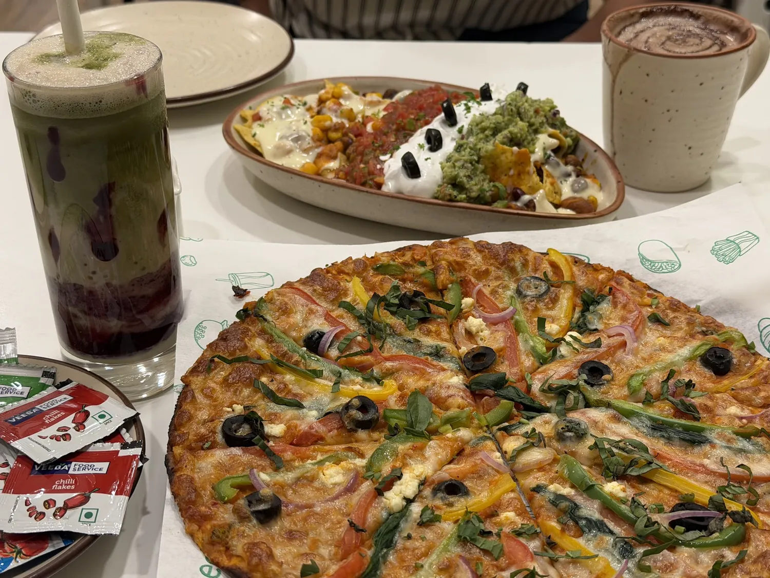 Pizza, nachos & matcha — a guest's table spread